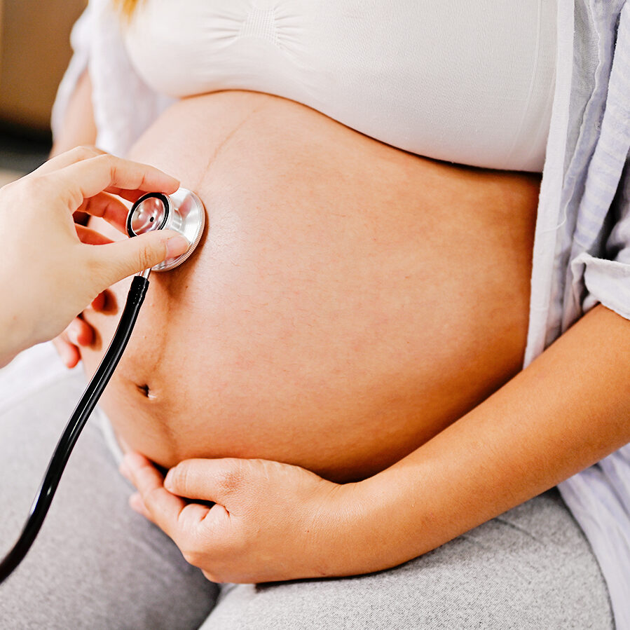 Hebamme hört Herztöne des Babys ab